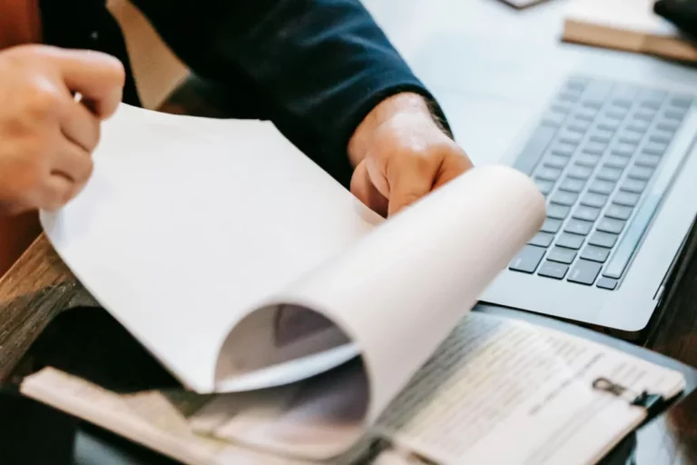 A person reviews case documents at a desk in front of a computer